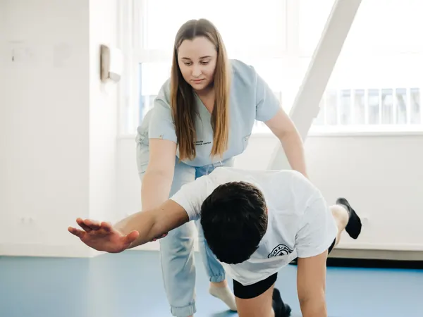 Fisioterapeuta guiando un estiramiento de pierna a un paciente